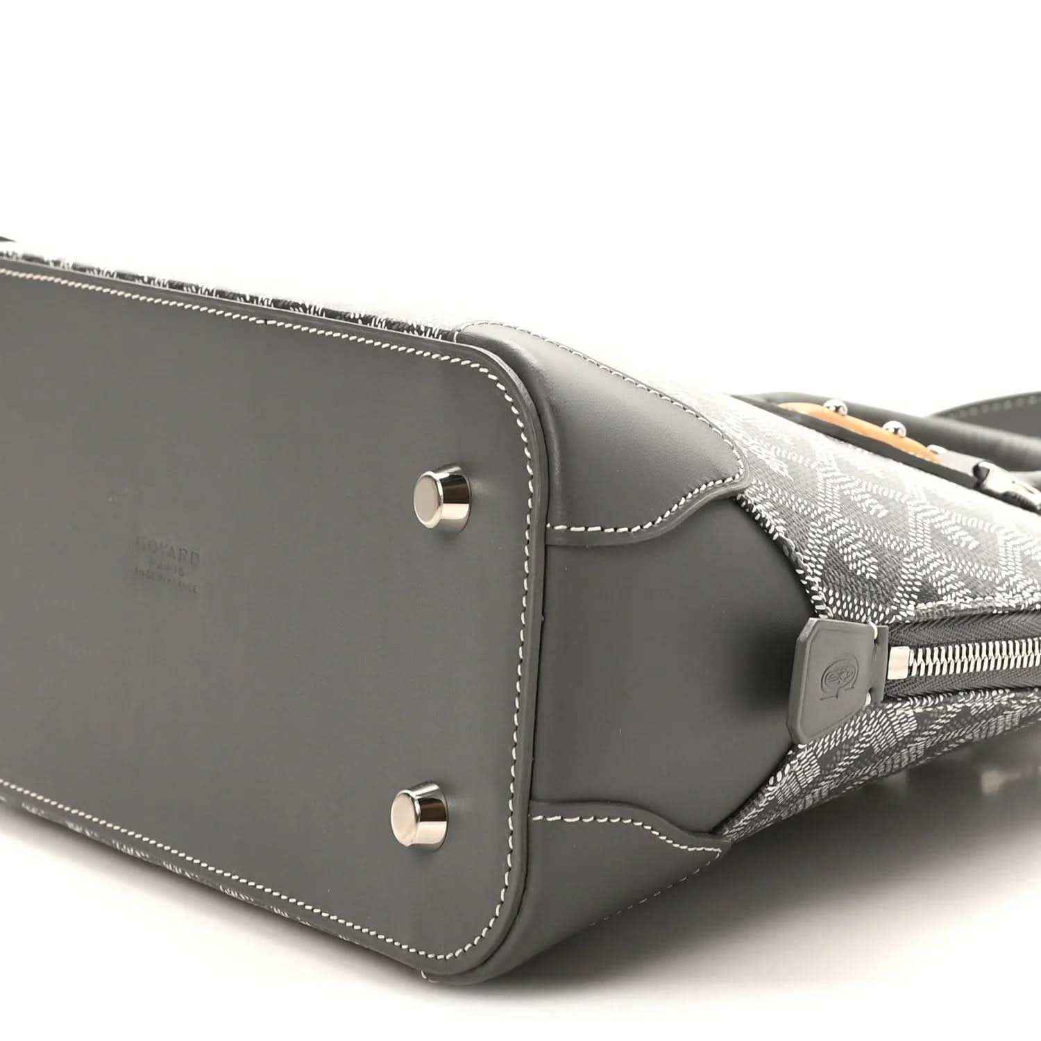 Grey handbag side panel with silver studs and contrast white stitching detail.