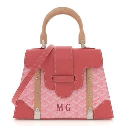 Pink canvas tote bag with wooden handles, leather trim, and stitched front panels.