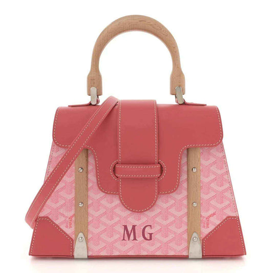 Pink canvas tote bag with wooden handles, leather trim, and stitched front panels.