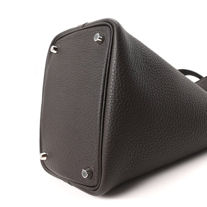 Dark brown leather tote bag side view with metal corner rings and textured finish