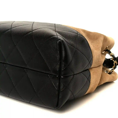 Black quilted small shopping bag end with stitched panel and beige suede side