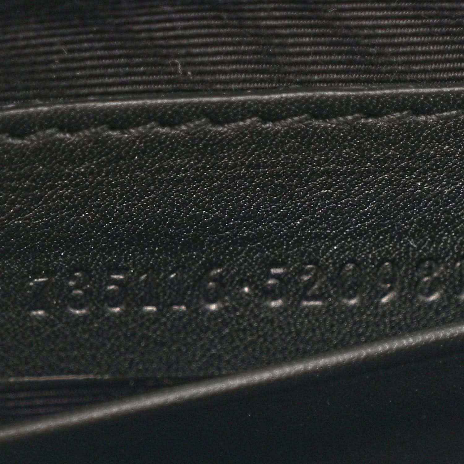 Close-up of stamped details on black mini bag strap area