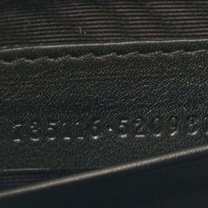 Close-up of stamped details on black mini bag strap area