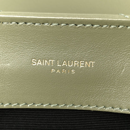 Light sage leather satchel interior wall with stitched trim and “SAINT LAURENT PARIS” text