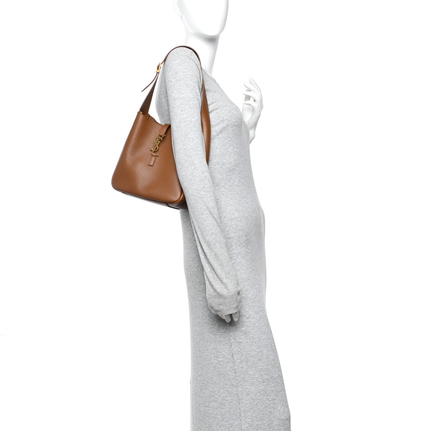 Tan leather hobo bag worn at the side with top handle and thin strap