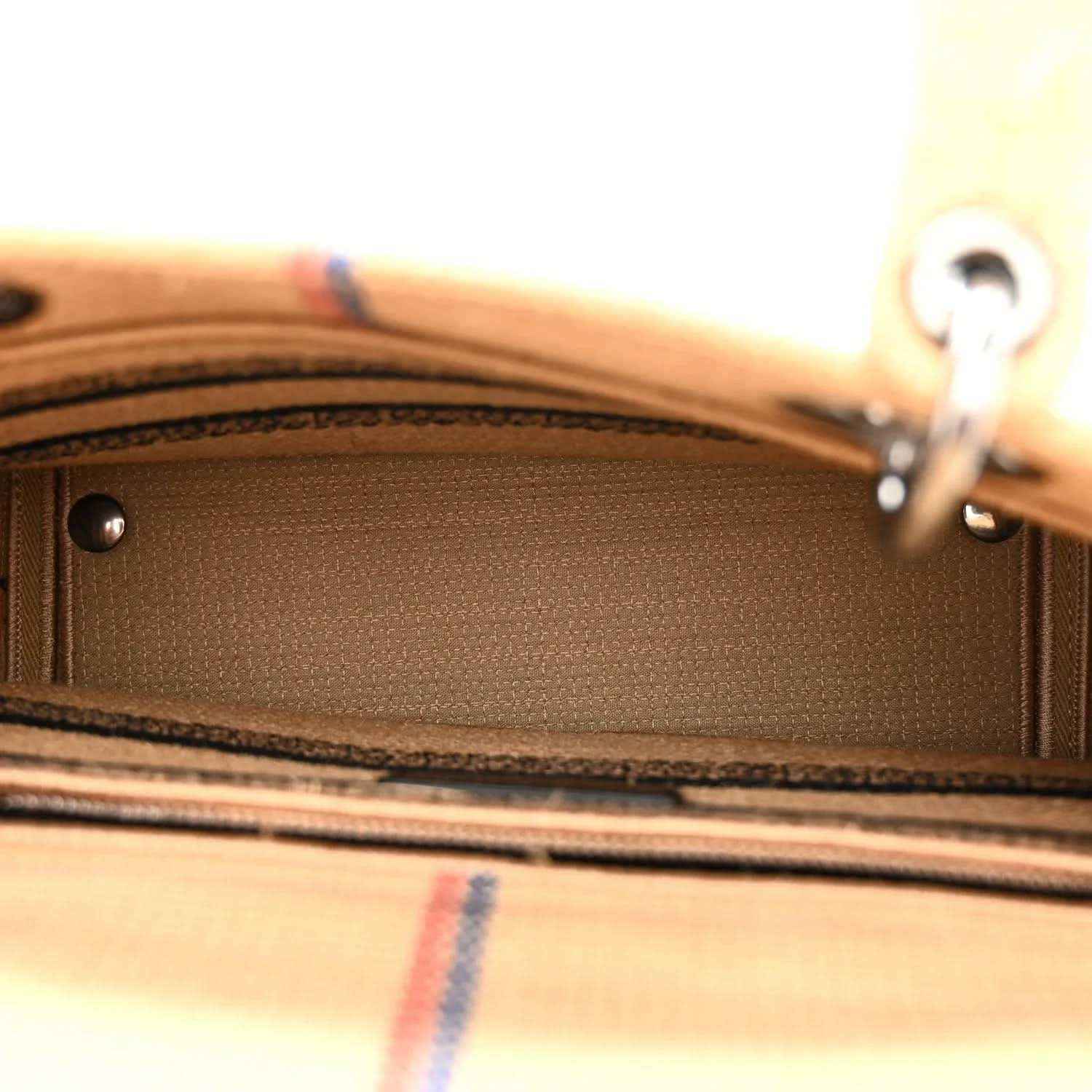 Beige jute tote bag interior edge with stitched seam and metal hardware