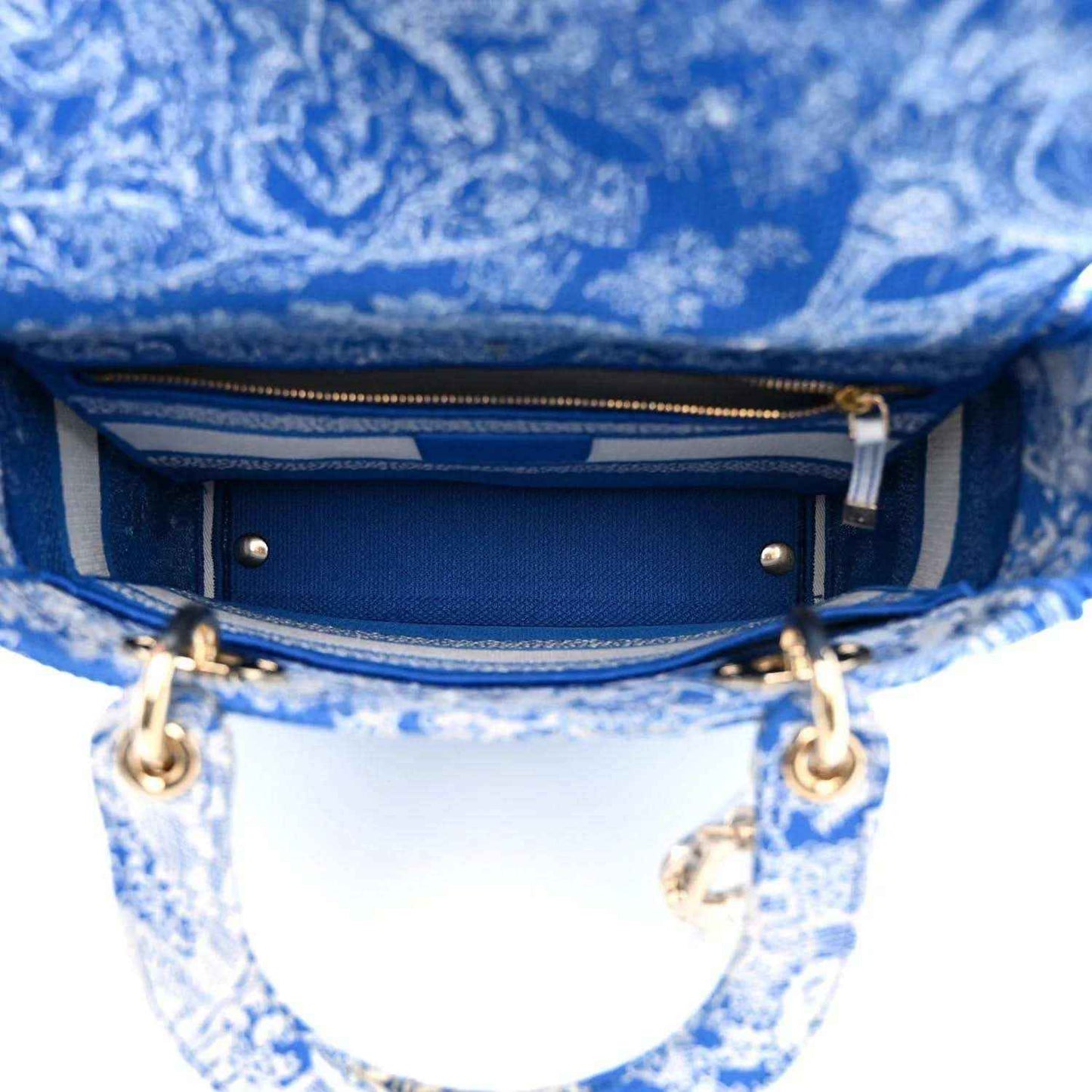 Dior tote bag interior view with blue lining, zipper track, and gold hardware