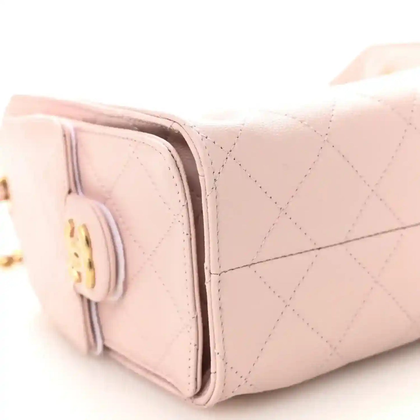 Light pink Chanel mini quilted leather handbag side with round turn-lock emblem