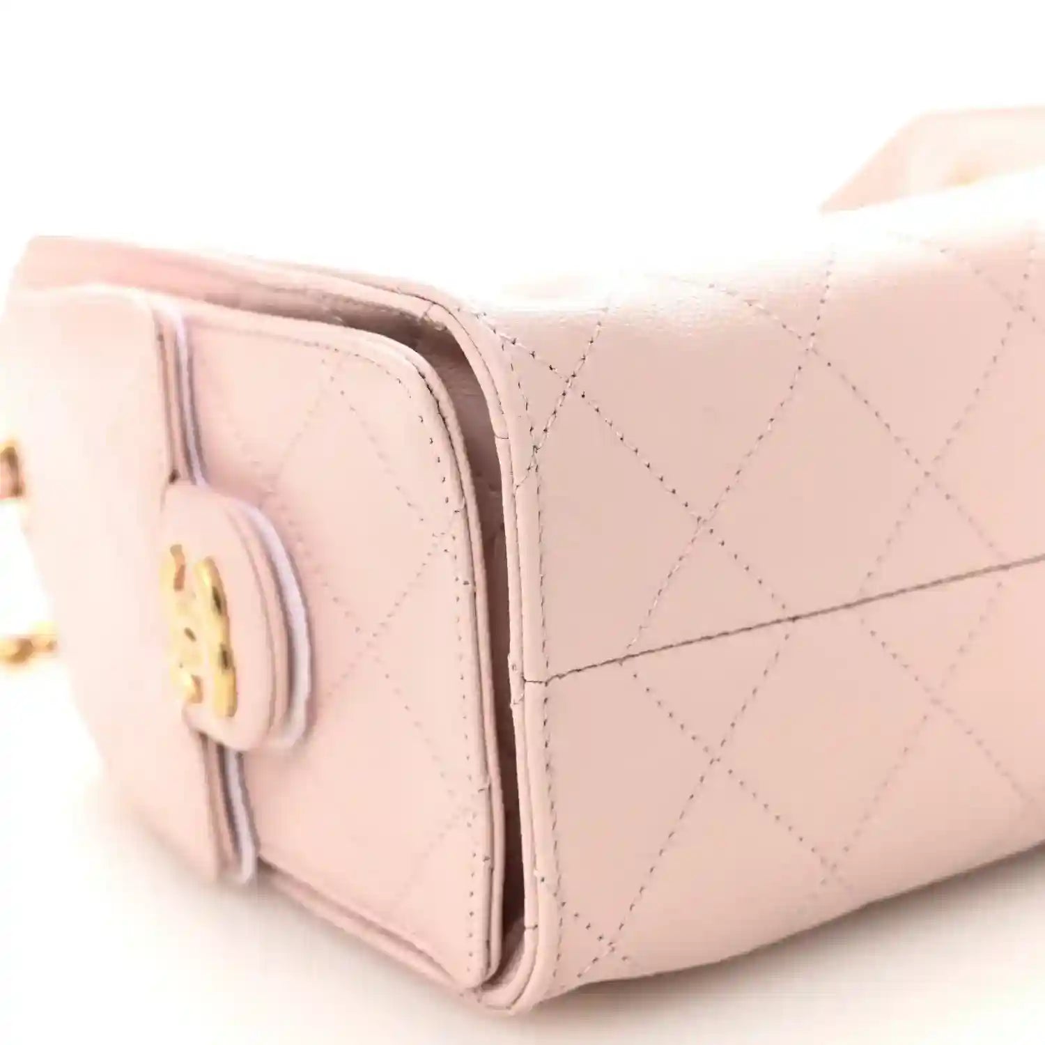 Light pink Chanel mini quilted leather handbag side with round turn-lock emblem