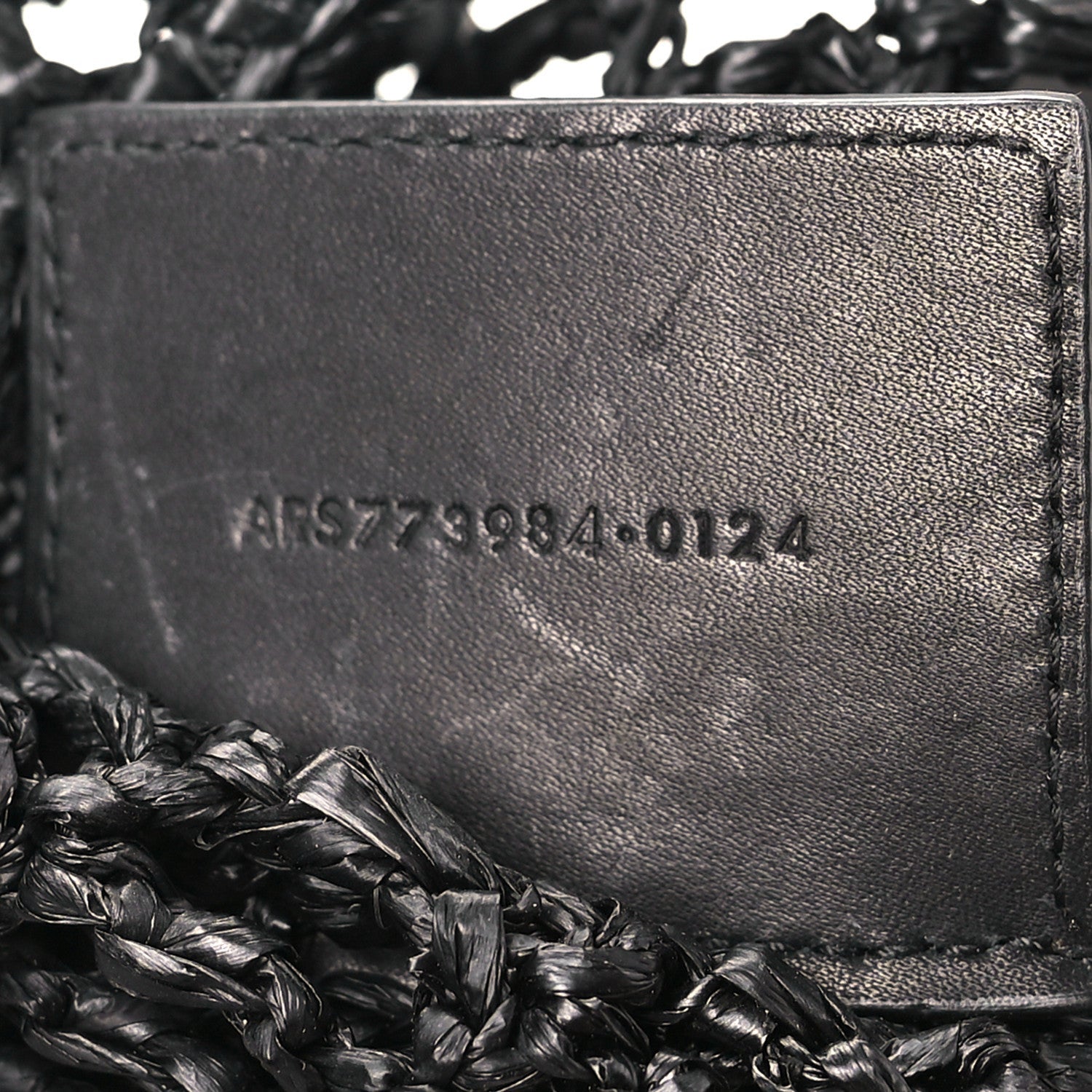 Black leather interior panel with embossed serial text on shoulder bag