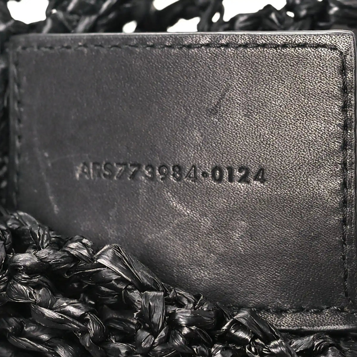 Black leather interior panel with embossed serial text on shoulder bag
