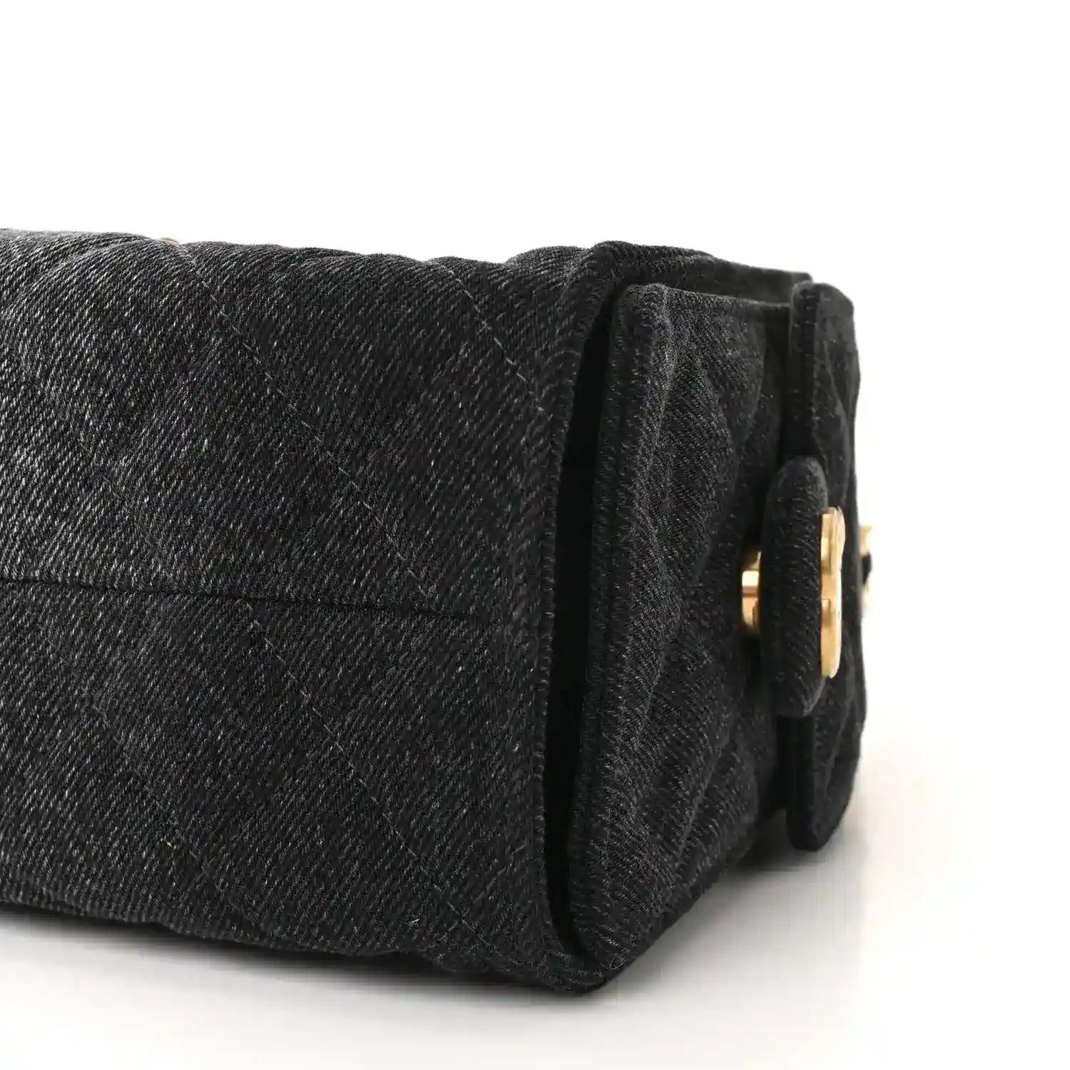 Black mini handbag end view with quilted texture and gold-tone ring detail