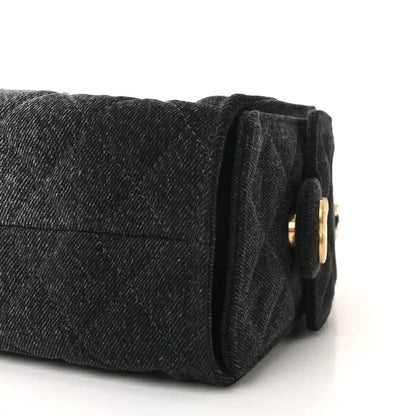 Black mini handbag end view with quilted texture and gold-tone ring detail