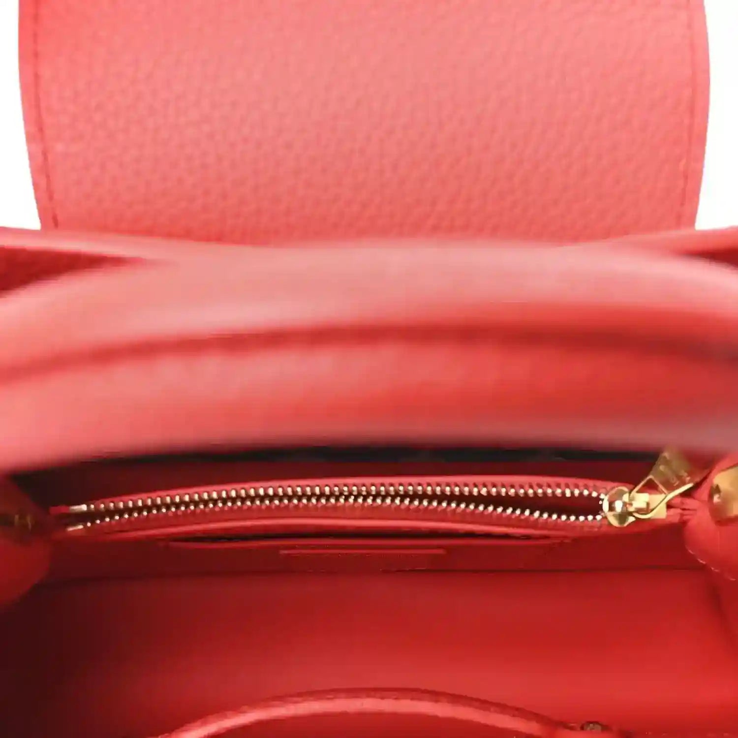 Red leather mini handbag interior view with visible gold zipper and lining.