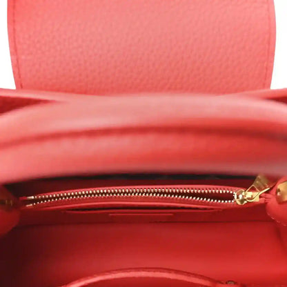 Red leather mini handbag interior view with visible gold zipper and lining.