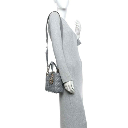 Grey quilted Lady Dior handbag worn crossbody with top handle and shoulder strap