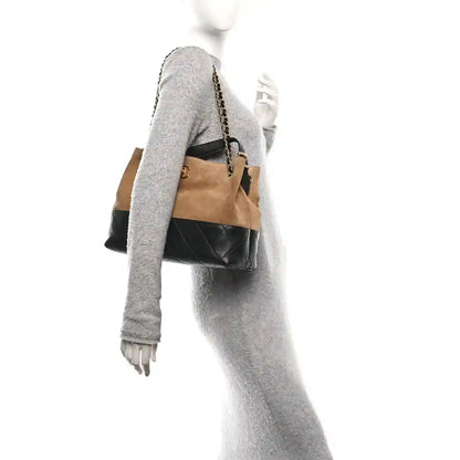 Beige suede small shopping bag with black quilted side and gold chain strap
