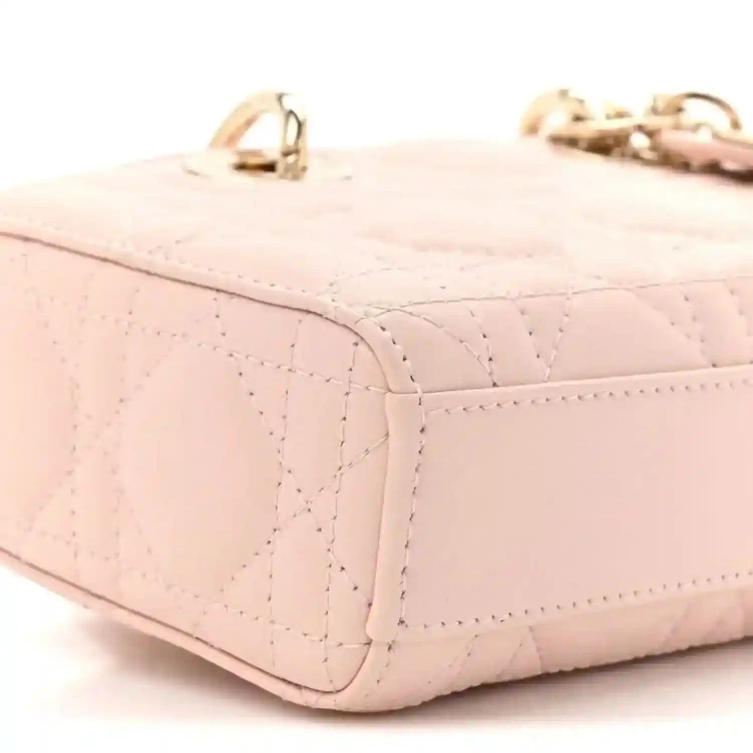 Pink quilted leather mini handbag side panel with stitched seams and curved base