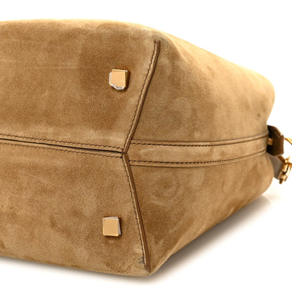 Suede bucket bag corner view with metal rivet tabs and stitched seams, golden tan