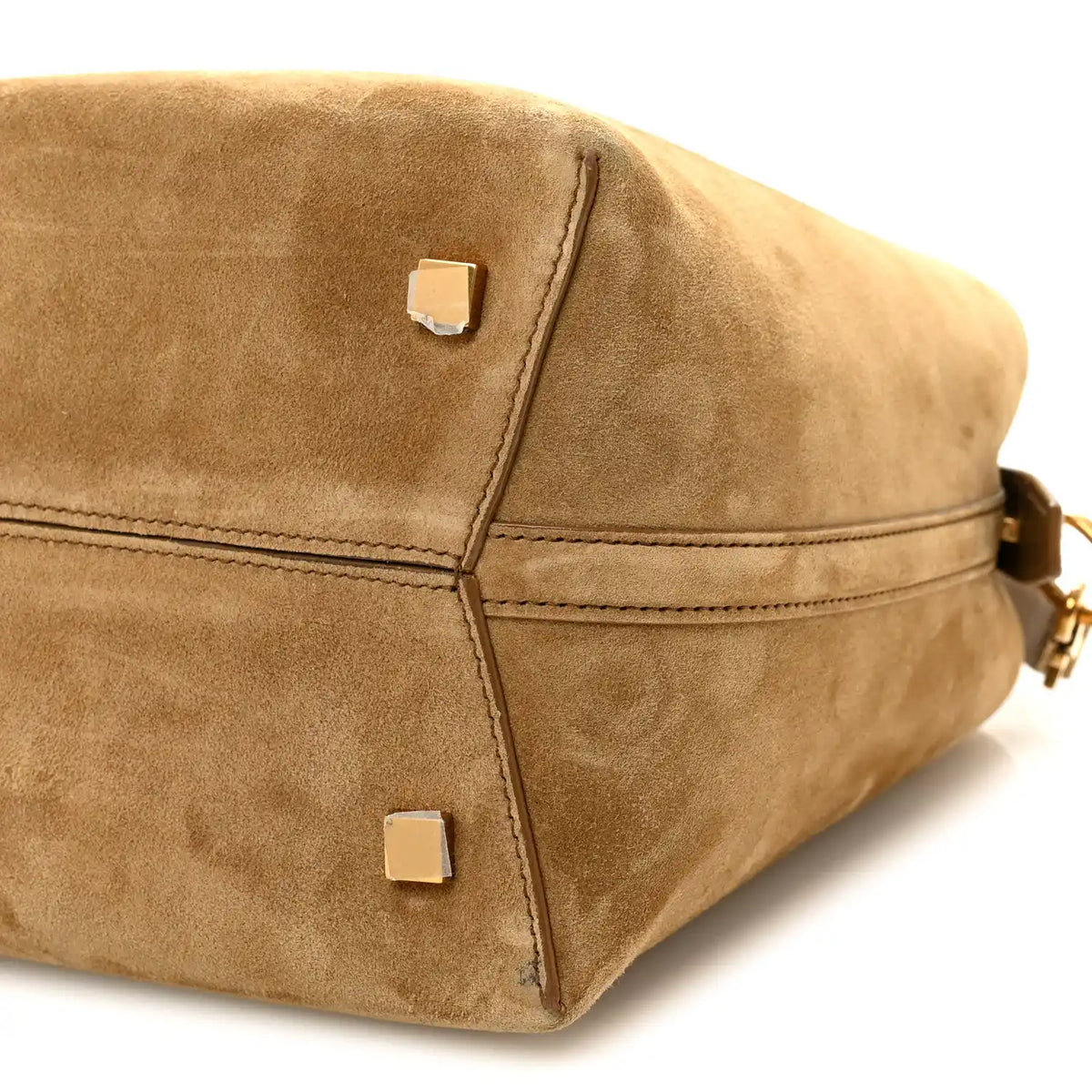 Suede bucket bag corner view with metal rivet tabs and stitched seams, golden tan