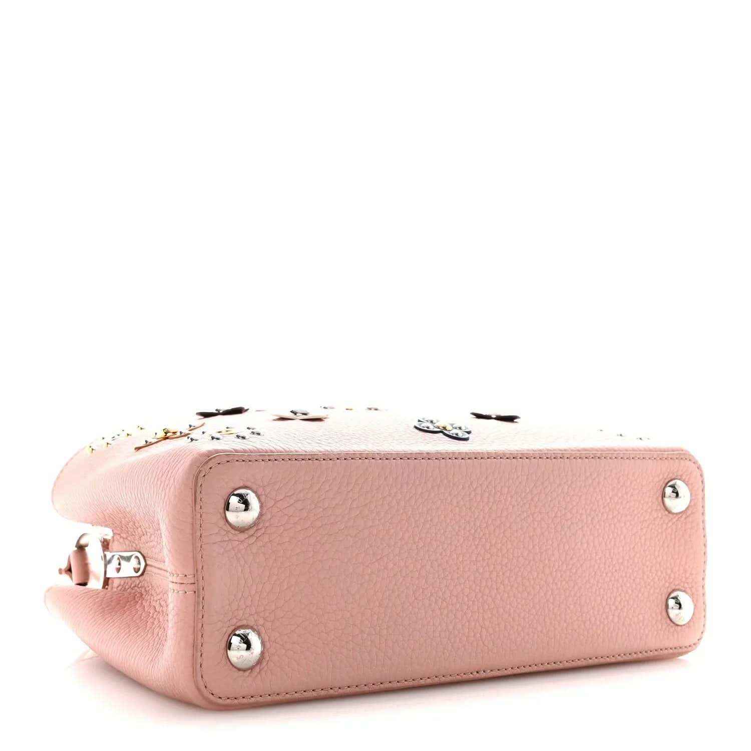 Pink leather handbag with top zip, studded front, and silver-toned metal feet