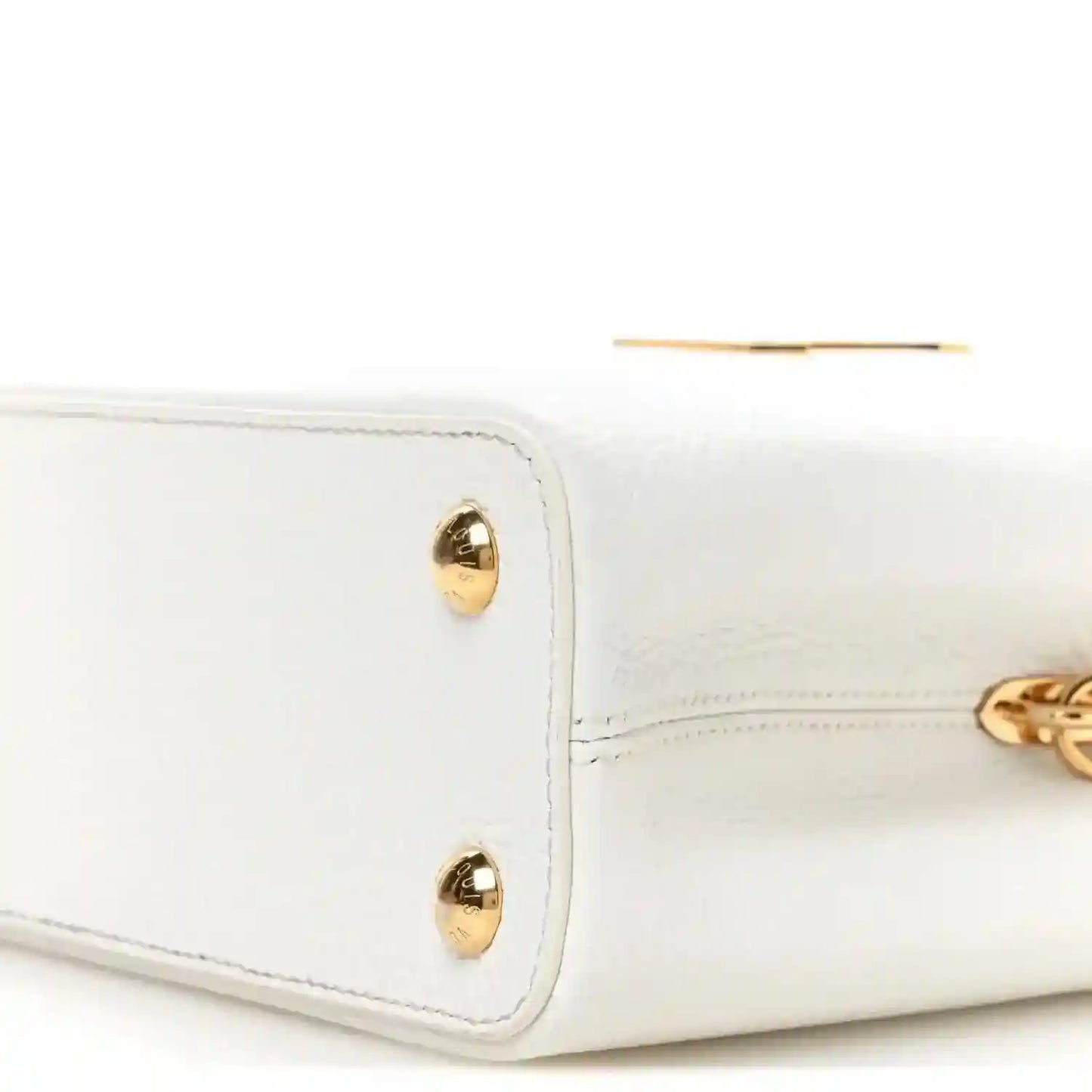 White leather handbag corner with two gold-tone studs and top edge stitching