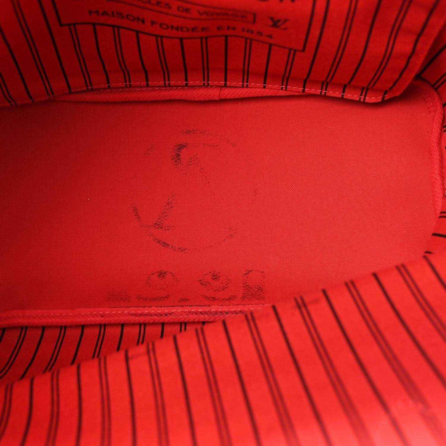 Red fabric lining with embossed monogram pattern inside the bag
