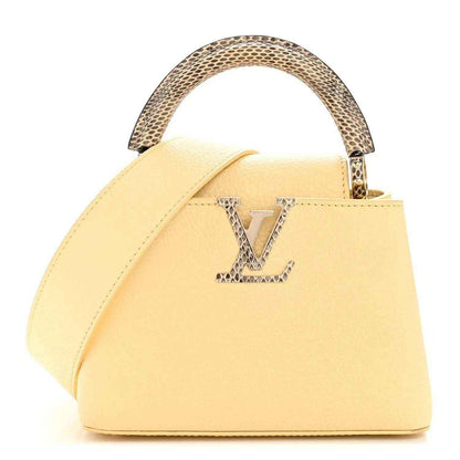 Cream mini handbag with top handle, snakeskin trim, and gold LV-style emblem on front.