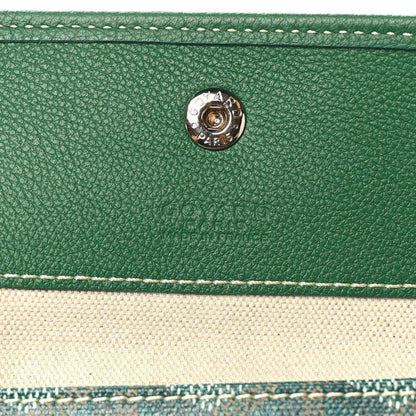 Green leather tab detail with circular metal snap on the tote bag