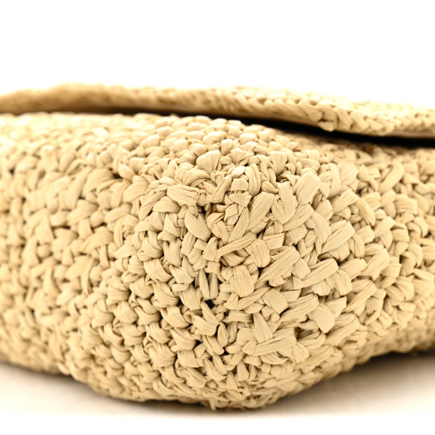 Natural raffia woven texture on shoulder bag exterior