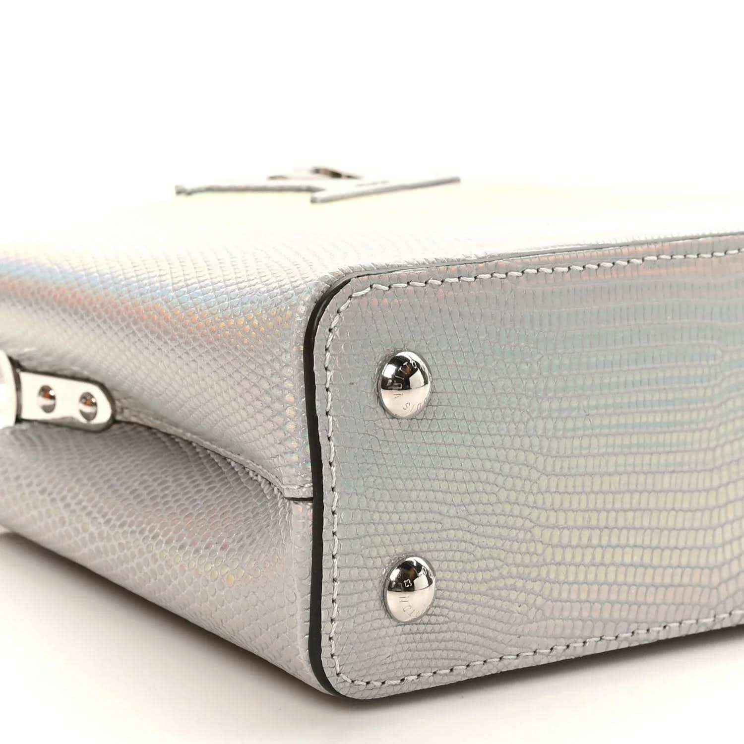 Iridescent lizard mini handbag corner close-up with silver rivets and stitching