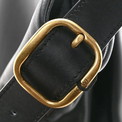 Gold-tone D-ring hardware on black leather shoulder bag strap