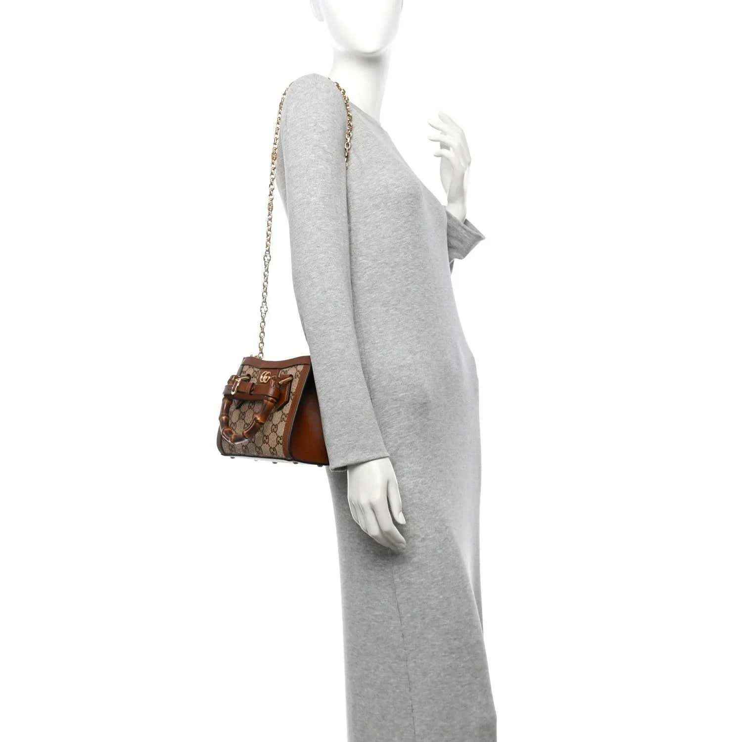 Mini tote bag held by a mannequin, with bamboo handles and a gold-tone chain strap