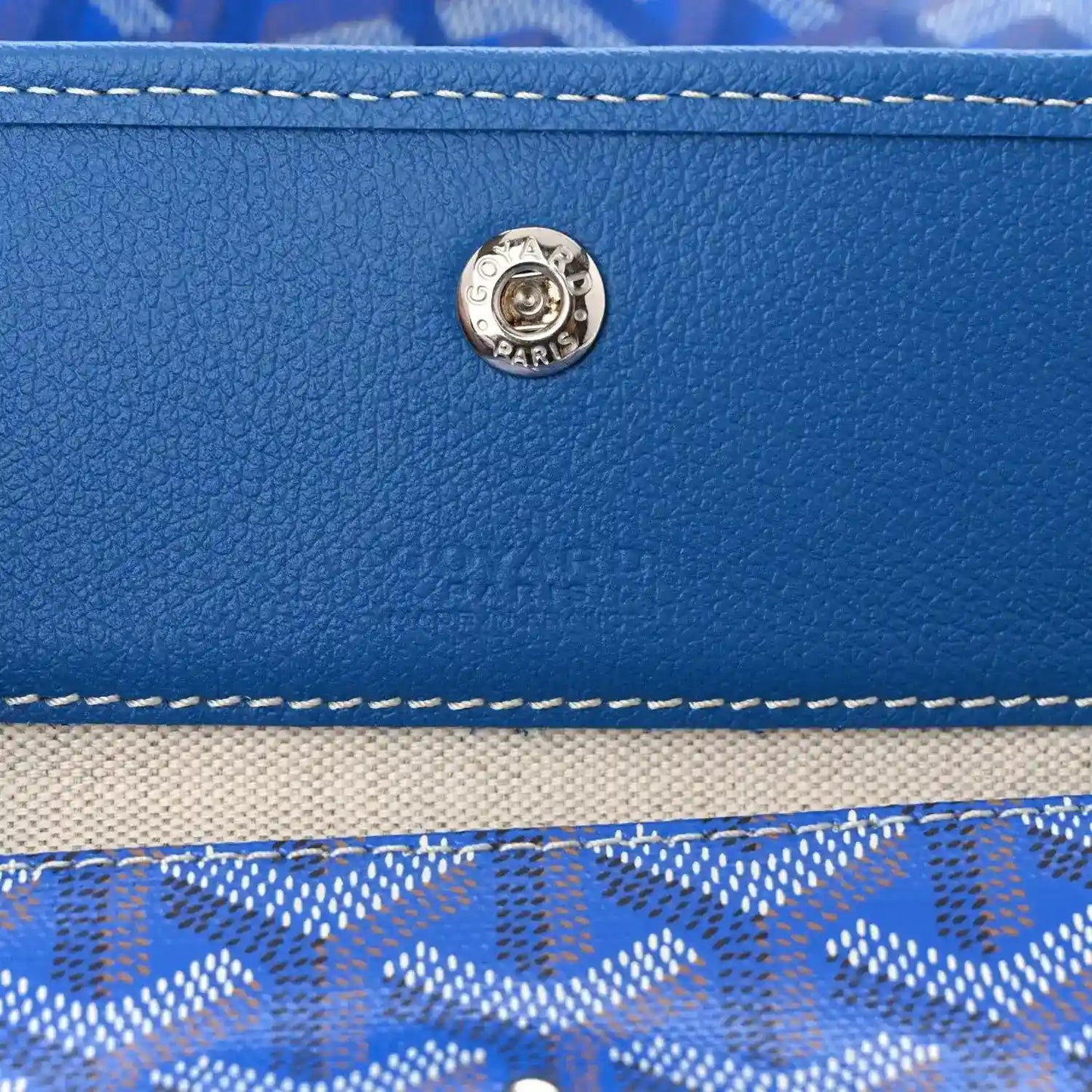 Sky blue leather trim with round metal clasp and double-row stitching on tote bag
