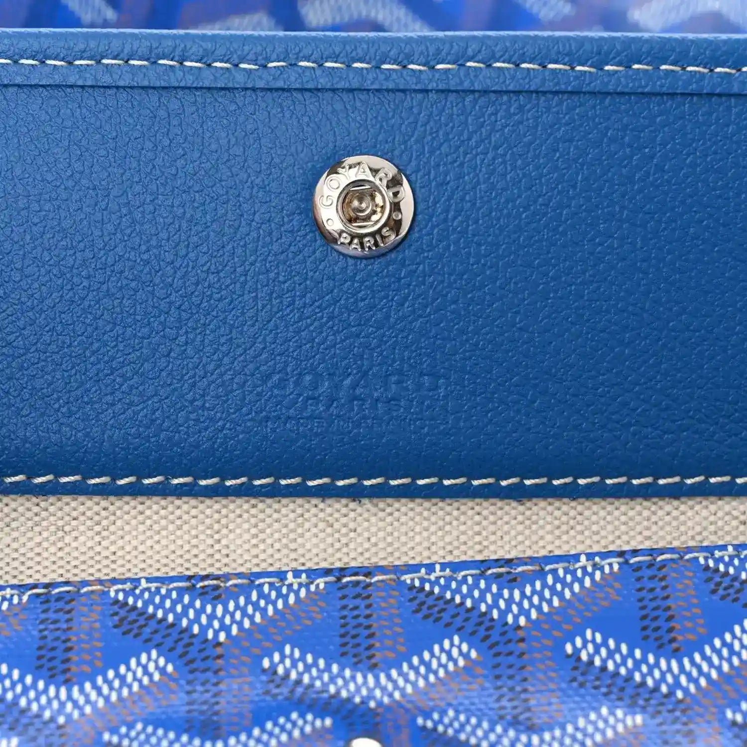 Sky blue leather trim with round metal clasp and double-row stitching on tote bag