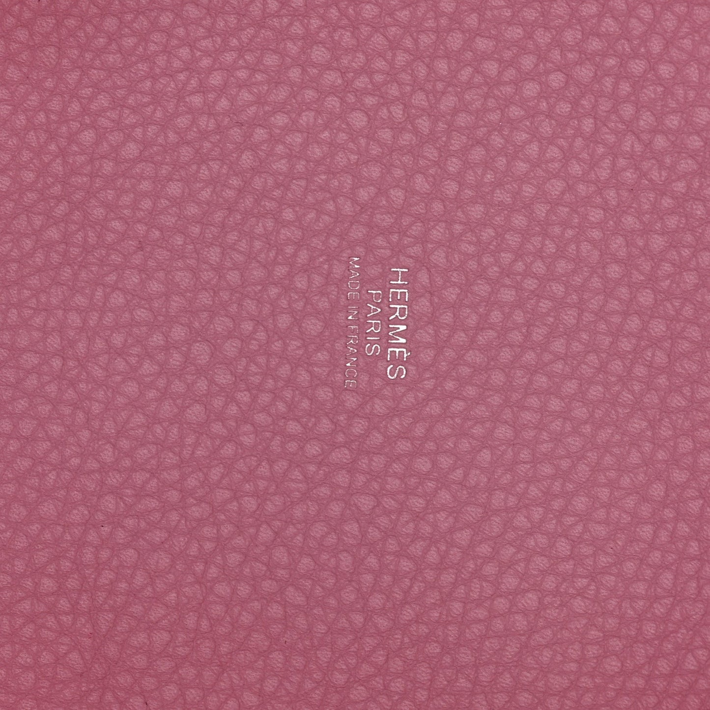 Rose pink textured leather panel with embossed brand lettering