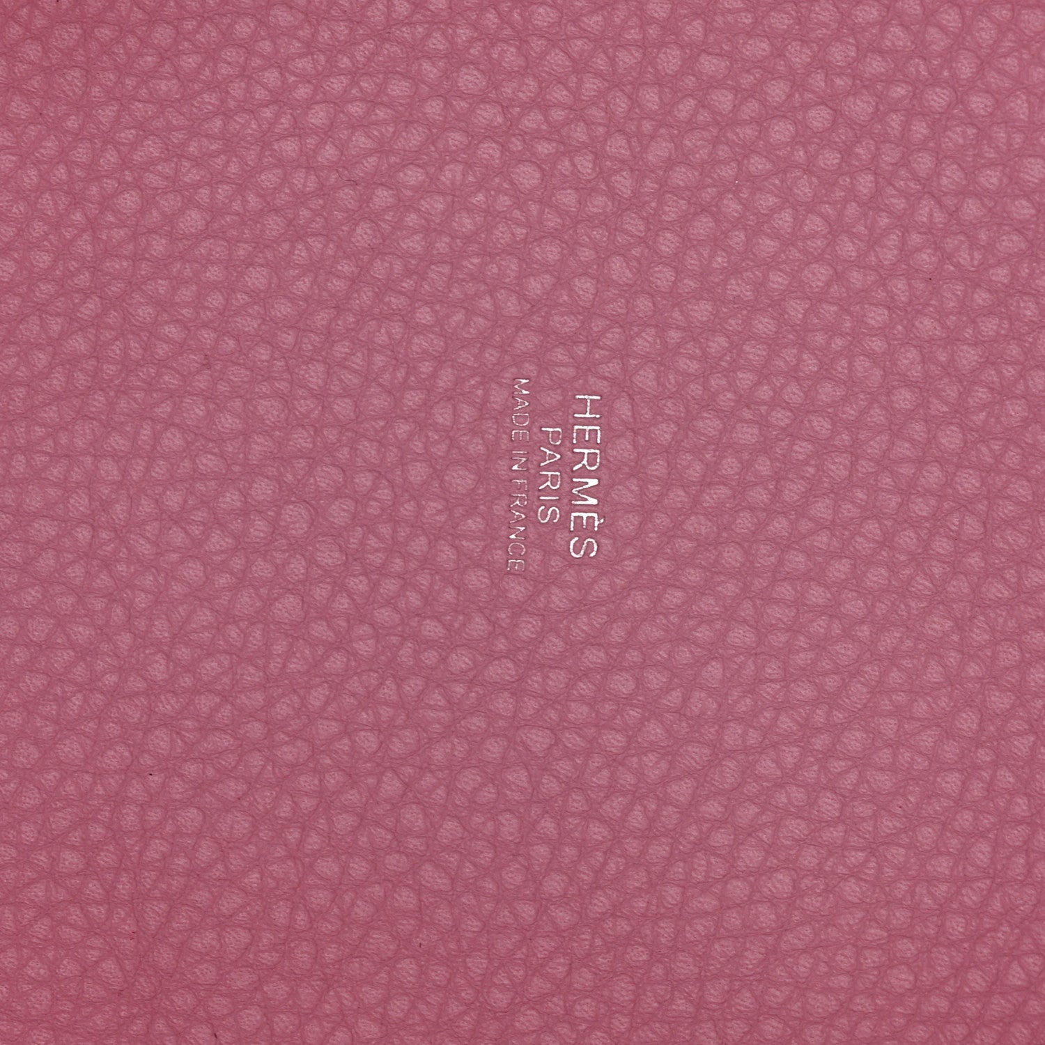 Rose pink textured leather panel with embossed brand lettering