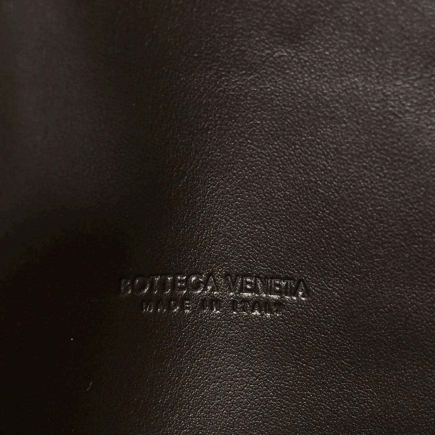 Embossed logo on dark leather clutch lining