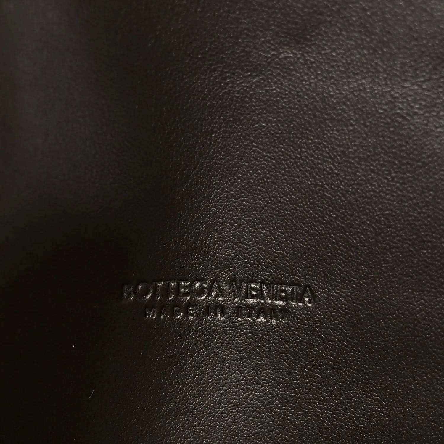 Embossed logo on dark leather clutch lining