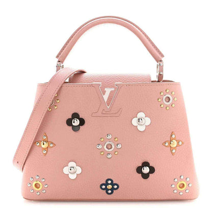 Pink leather handbag with top handle, jeweled flower appliqués, and LV-style logo