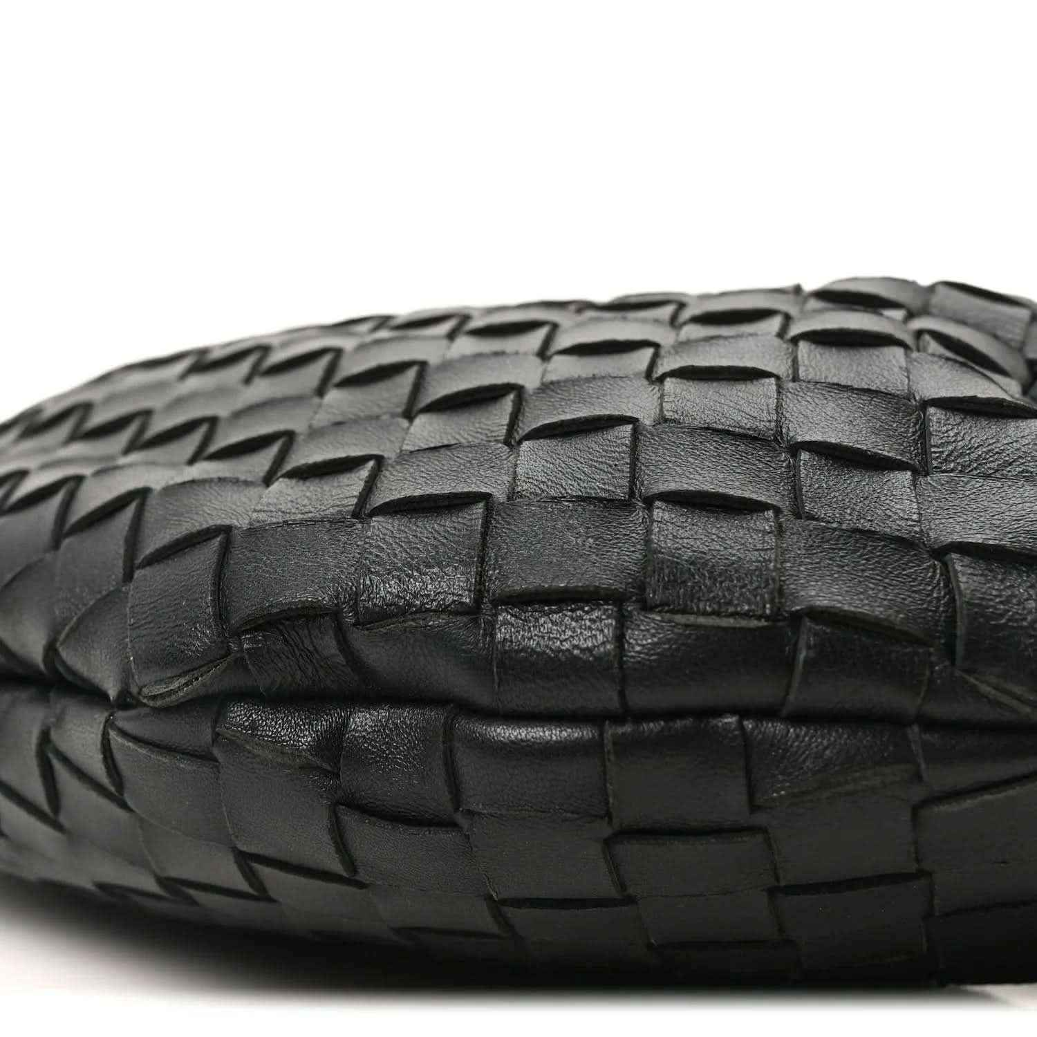 Bottega Veneta intrecciato nappa bag bottom in black with woven texture close-up.
