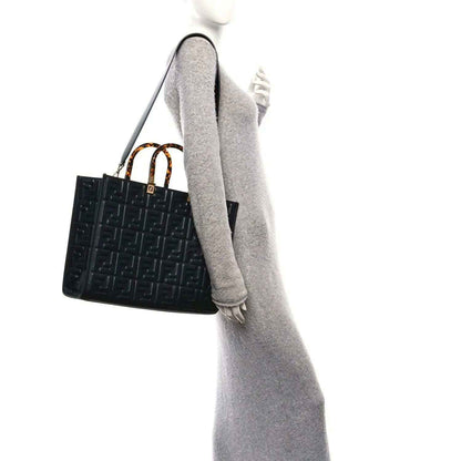 Black embossed leather tote bag with FF pattern and short top handles, viewed side