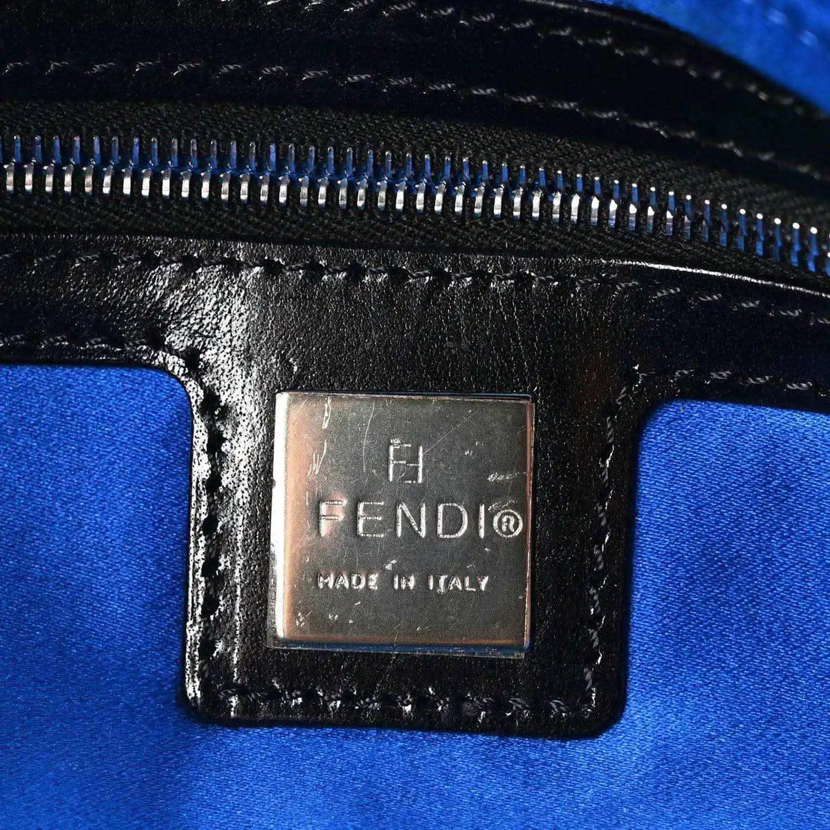 Blue fabric-lined interior with zipper and FENDI logo leather patch