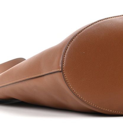 Close-up of tan-brown calfskin tote corner with curved seam and stitched edge