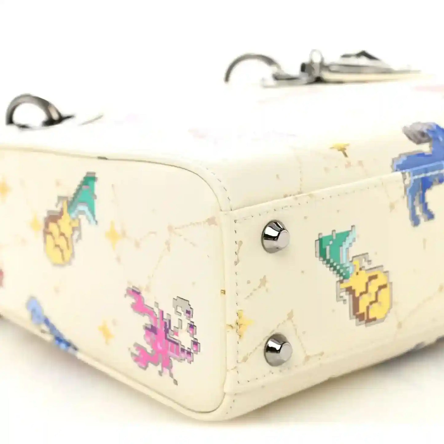 Mini Lady Dior bag corner close-up, white leather with pixel zodiac and silver studs