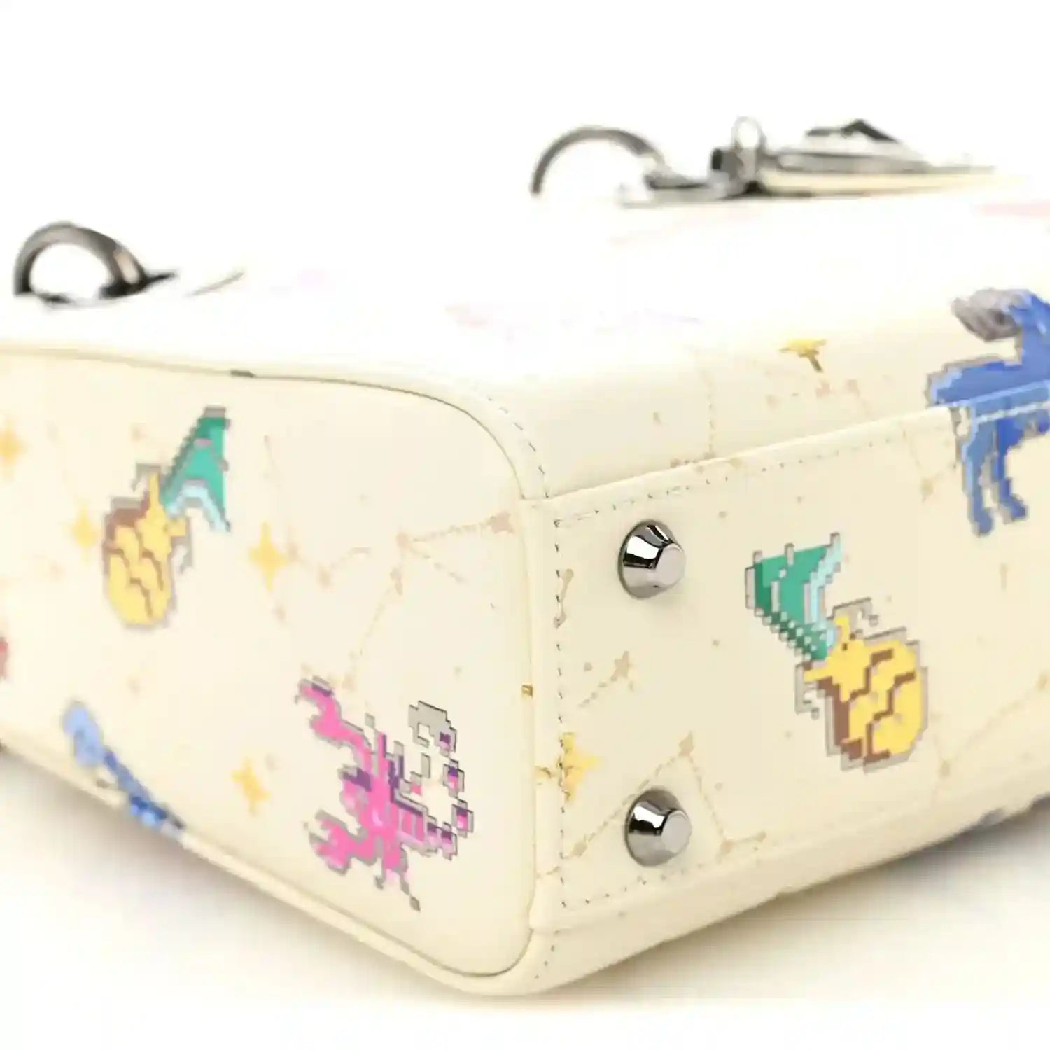 Mini Lady Dior bag corner close-up, white leather with pixel zodiac and silver studs