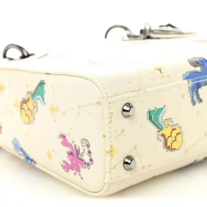 Mini Lady Dior bag corner close-up, white leather with pixel zodiac and silver studs
