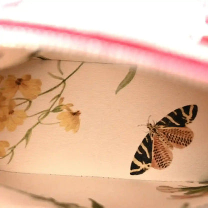 Printed fabric swatch with floral and butterfly motifs in beige and black