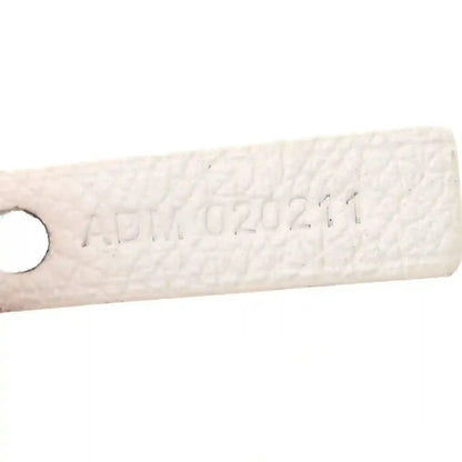 Goyard Saint Louis PM tote handle tab with embossed markings on white canvas