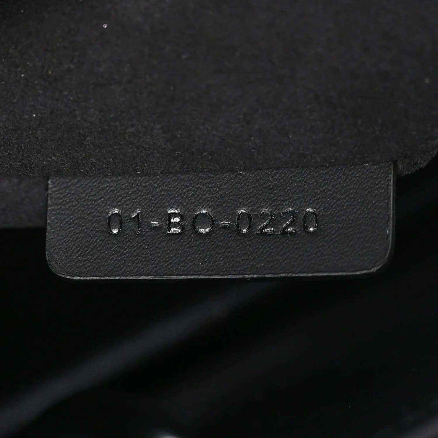 Black leather handbag tag with molded serial text